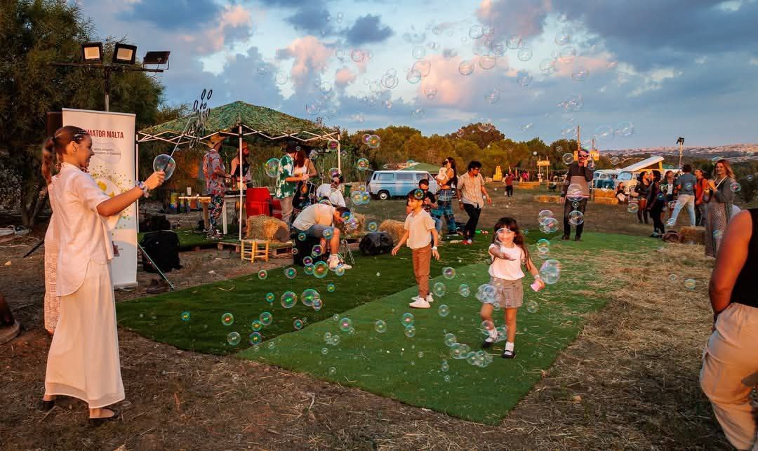 Giant bubbles over a crowd of children outdoors