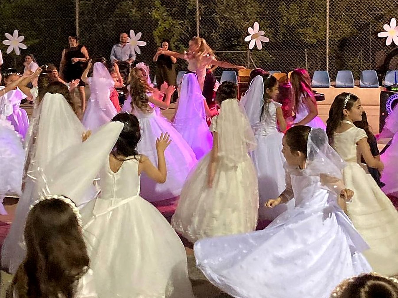 Girls in Holy Communion dresses dancing at a party in Malta